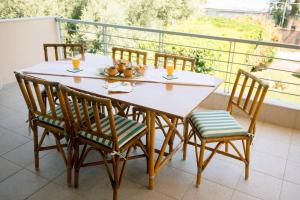 a white table and chairs on a balcony at Aphrodite Residence - Seafront apartment, Melissi in Melíssion