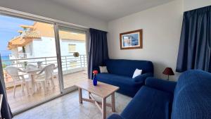a living room with a blue couch and a balcony at Talima Vyb Dénia in Denia