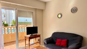 a living room with a couch and a television at Talima Vyb Dénia in Denia