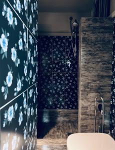 a bathroom with blue and white flowers on the wall at La Casetta di Borgo Appartamento Albero in Lajatico +25 photos
