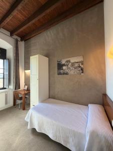 a bedroom with a white bed and a desk at Hospedería de Alesves in Villafranca