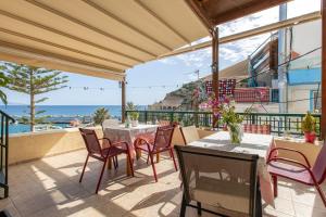 a patio with tables and chairs and a view of the ocean at Akteon Rooms in Agia Galini