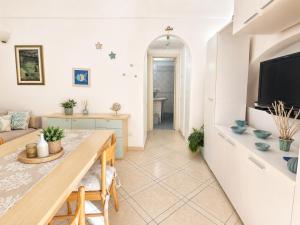 a living room with a table and a tv at Maridea - Appartamento al Tramonto in Ponza +12 photos