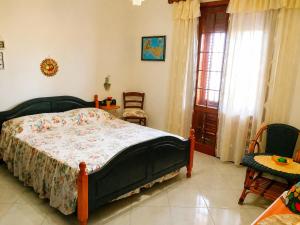 a bedroom with a bed and two chairs and a window at Guest House Al Giardino dei Limoni in Favignana