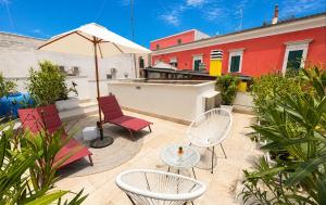 a patio with chairs and a table and an umbrella at Mamaco Trani Homey in Trani