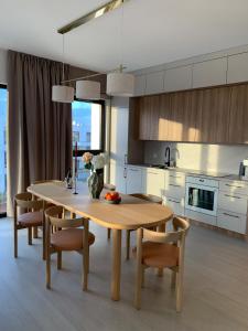 a kitchen with a wooden table and some chairs and a table at SolMarina Apartment for Rent in Wiślinka