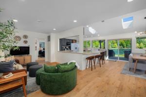 a living room with a green couch and a kitchen at Seal Cove in Lilliwaup