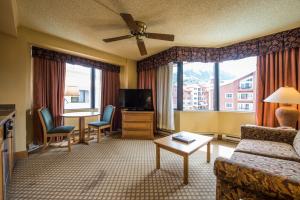 a living room with a couch and a television at The Grand Lodge, A Vail Resorts Property in Mount Crested Butte