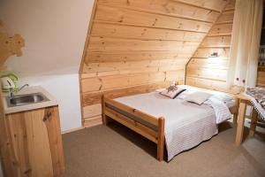 コシチェリスコにあるWilla Jedlickaの木製の壁のベッドルーム1室(ベッド1台付)