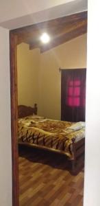 a mirror in a bedroom with a bed at La Posta de Gherard in Maimará
