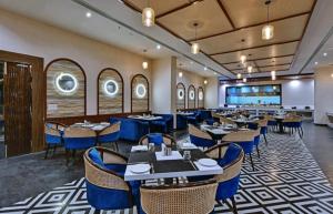 a restaurant with tables and chairs in a room at Golden Studio With Swimming pool in Jaipur
