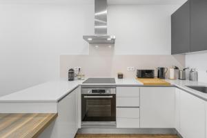 a white kitchen with a stove and a sink at JB RiaMar l by Meditrust in Alvor