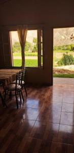 a dining room with a table and chairs and a window at La Posta de Gherard in Maimará