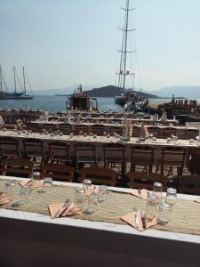 a table with chairs and wine glasses and a marina at Villa Aristoteles in Halki