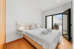 a white bedroom with a bed with white sheets at JB RiaMar l by Meditrust in Alvor +12 photos