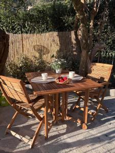 a wooden table with a bowl of fruit and two chairs at Crueza de ma in Bonassola