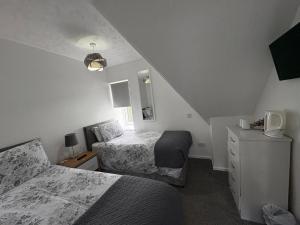 a bedroom with two beds and a staircase at Glendale Guesthouse in Oban