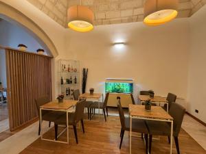 a dining room with tables and chairs and a window at Dimora dei Salentini in Lecce