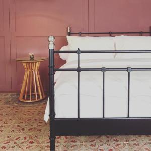 - un lit noir avec un oreiller blanc et une table de chevet dans l'établissement Spiegel Home Studio, à Semarang