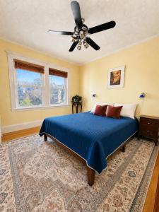 a bedroom with a blue bed and a ceiling fan at Victorian Condo in Boston
