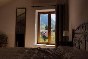 a bedroom with a bed and a window with a view at Casa dello Scoiattolo in Bieno