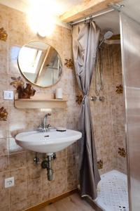 a bathroom with a sink and a mirror and a shower at Casa dello Scoiattolo in Bieno