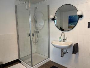 a bathroom with a shower and a sink and a mirror at Auszeit in Melsungen