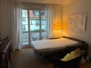 a bedroom with a bed and a large window at Maison Mosgenstein in Bern