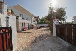 a house with a gate and a sign on a driveway at Vila Feimi in Ksamil