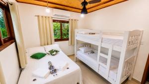 a bedroom with a bunk bed and a white bunk bed at Refúgio Casinha Branca in Duque de Caxias +35 photos