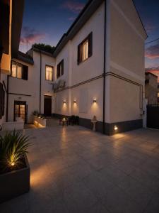 a large white building with a patio at night at Stornelli Suite & Apartments in Avezzano