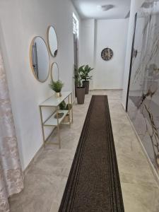 a hallway with mirrors and a table and a rug at Stornelli Suite & Apartments in Avezzano +80 photos