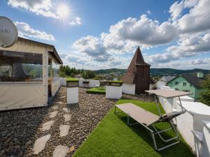 a rooftop patio with tables and chairs and a building at Hotel Three Korony in Skhidnitsa