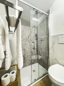 a bathroom with a shower with a toilet and towels at Hotel Caffaro in Genoa +42 photos