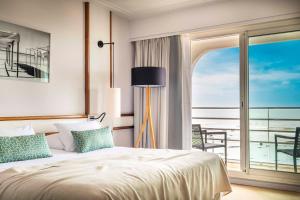 a bedroom with a bed and a view of the ocean at Atlantic Hôtel & Spa in Les Sables-d'Olonne