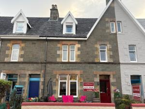 a house with pink chairs in front of it at Glendale Guesthouse in Oban