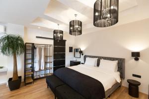 a bedroom with a bed and two chandeliers at Apollonio Suites in Korinthos