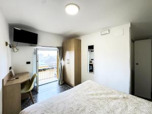 a bedroom with a bed and a desk and a window at Hotel Caffaro in Genoa