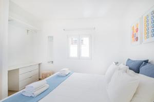 a white bedroom with a bed and a window at Vista del Mar Guest House in Albufeira