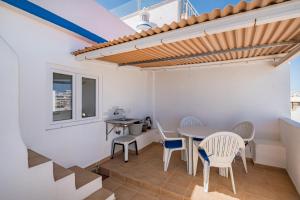 a patio with a table and chairs and a window at Vista del Mar Guest House in Albufeira