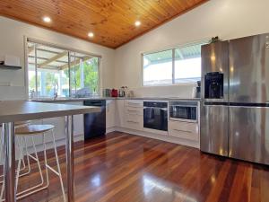 a large kitchen with stainless steel appliances and wooden ceilings at Brownies on Birch in Amity Point