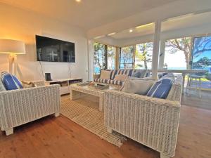 a living room with two couches and a tv at Sandy Shores in Amity Point