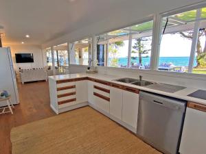 a kitchen with white cabinets and a view of the ocean at Sandy Shores in Amity Point