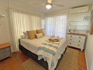 a bedroom with a bed and a dresser and a window at Sandy Shores in Amity Point