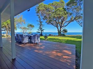 a porch with a table and chairs and the ocean at Sandy Shores in Amity Point