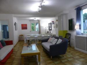a living room with a couch and a table at Maison familiale Villa Eolie, 10mn de la mer en voiture in Tregueux