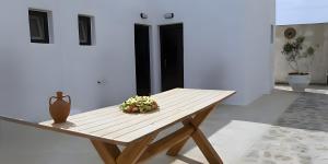 a wooden table with a flower arrangement on it at Maria's Private Space - Mykonos in Ano Mera +19 photos