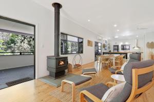 a living room with a wood stove and a table at Salty Beach in Amity Point
