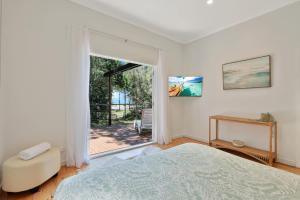 a bedroom with a bed and a large window at Salty Beach in Amity Point