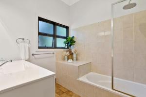 a white bathroom with a tub and a sink at Salty Beach in Amity Point +19 photos